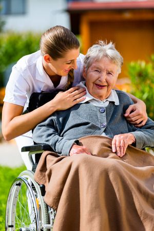 37893893 - senior woman in nursing home with nurse in garden sitting in wheelchair