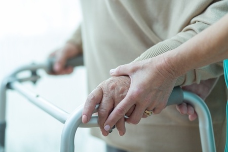 48725599 - close-up of woman using walker assisted by carer